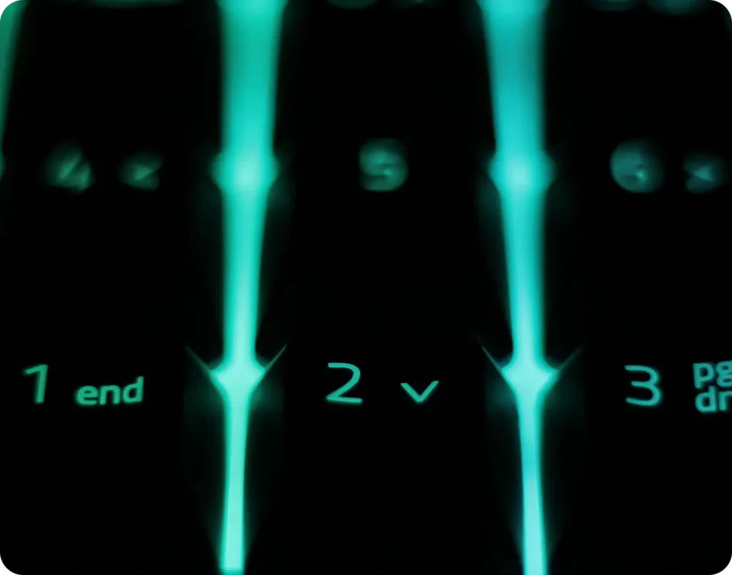 Zbliżenie na klawiaturę z neonowym podświetleniem cyfr i symboli